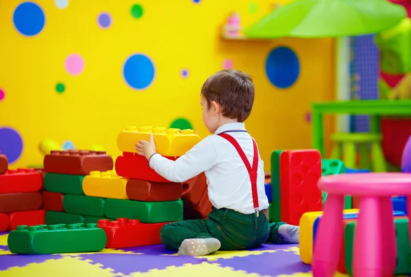 Bambino felice giocando con i blocchi di giocattoli nella scuola materna — Foto Stock