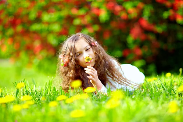 Belle fille reniflant les fleurs dans le parc du printemps — Photo