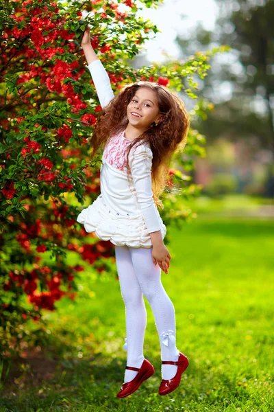跳跃在春天的花园里的漂亮女孩 — 图库照片