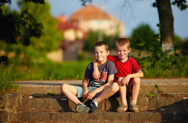 Portrait of young friends sitting on stairs — Stock Photo, Image
