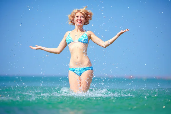 Pretty girl jumping in sea water — Stock Photo, Image