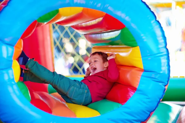 Glückliche Kinder spielen auf aufblasbarem Attraktionsspielplatz — Stockfoto