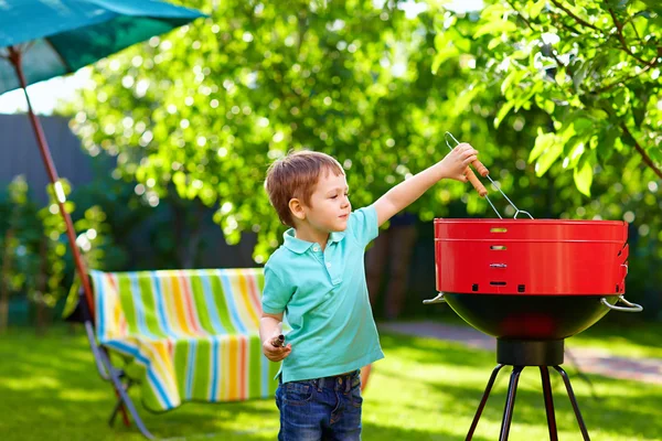 Kind grillt Essen auf Hinterhofparty — Stockfoto