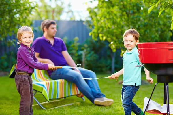 Happy kids fighting with kitchen items on picnic — Stock Photo, Image