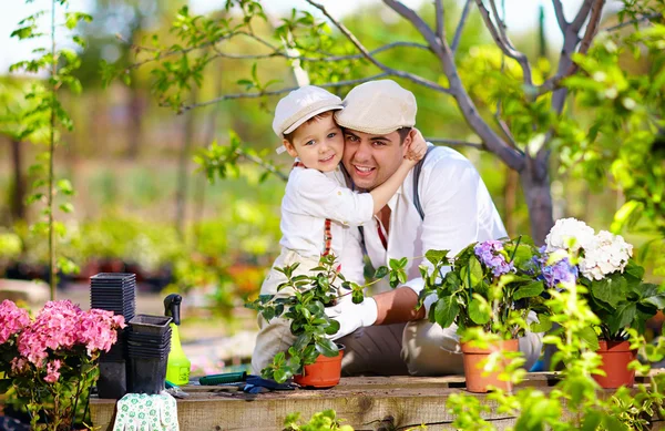 Happy family cares for plants in spring garden — Stock Photo, Image