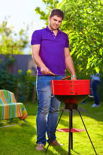 男は裏庭でグリル ソーセージを焙煎 — ストック写真