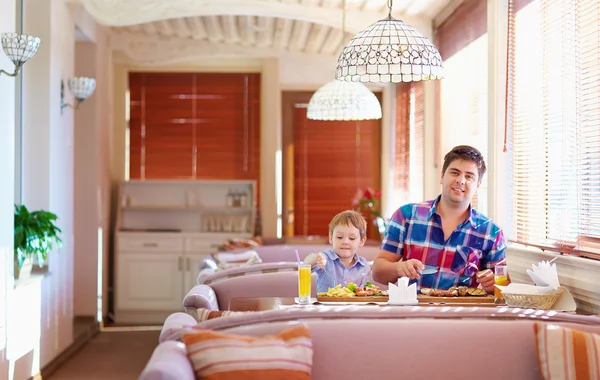 Father and son have a dinner in restaurant — Stock Photo, Image