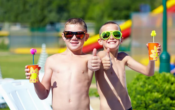 Happy teenage boys showing thumbs up in aquapark — Stock Photo, Image