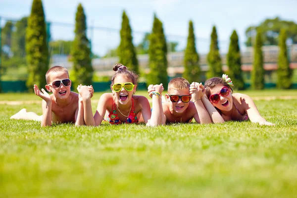 Happy dospívající přátelé ležící na trávníku v létě — Stock fotografie