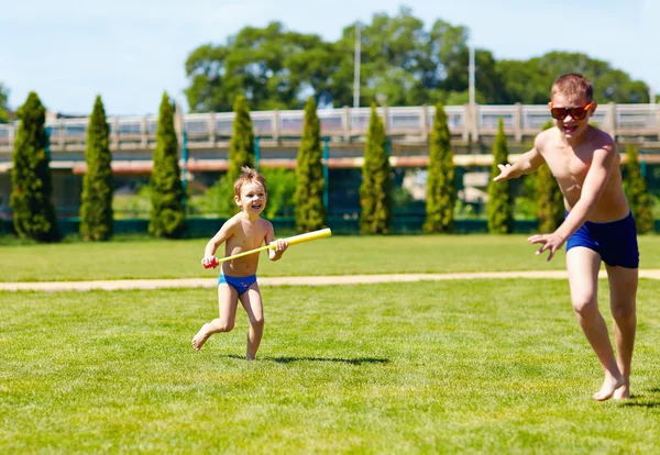 Um menino perseguindo outro com brinquedo de água, verão — Fotografia de Stock