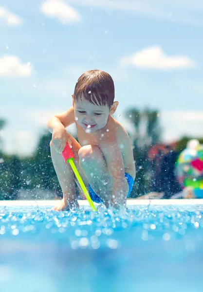 Lindo chico divirtiéndose, jugando cerca de la piscina — Foto de Stock