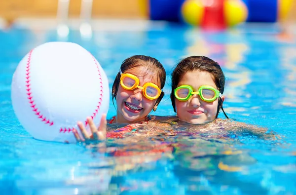 Jeugdvrienden spelen met de bal in het zwembad — Stockfoto