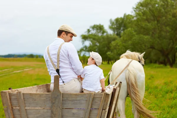 Far och son, jordbrukare rida en häst-vagn — Stockfoto