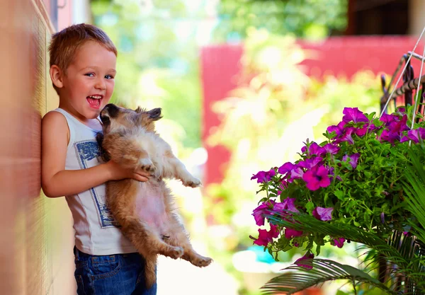 最愛の子犬を保持している興奮した少年 — ストック写真