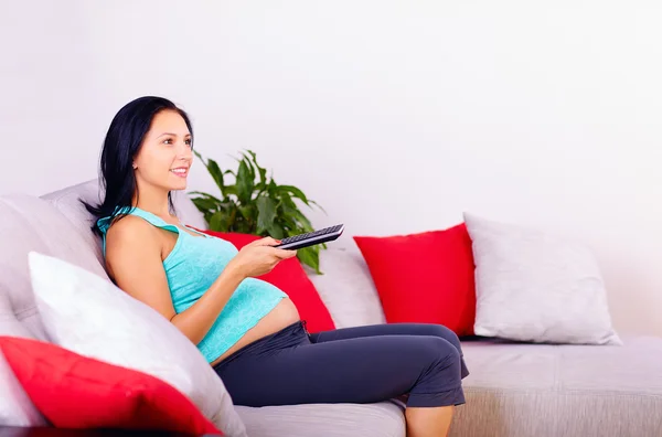 Donna incinta guardando la tv a casa — Foto Stock