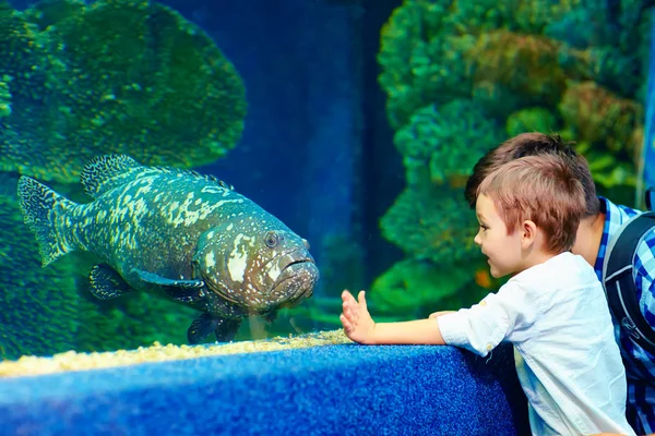 Criança feliz comunicando com peixes no oceanário — Fotografia de Stock