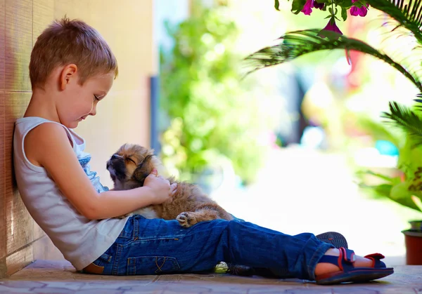 Joven chico abrazando poco cachorro — Foto de Stock