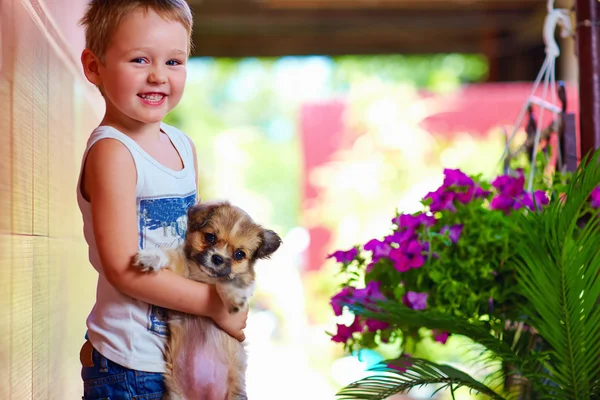 Joven chico sosteniendo poco cachorro perro — Foto de Stock