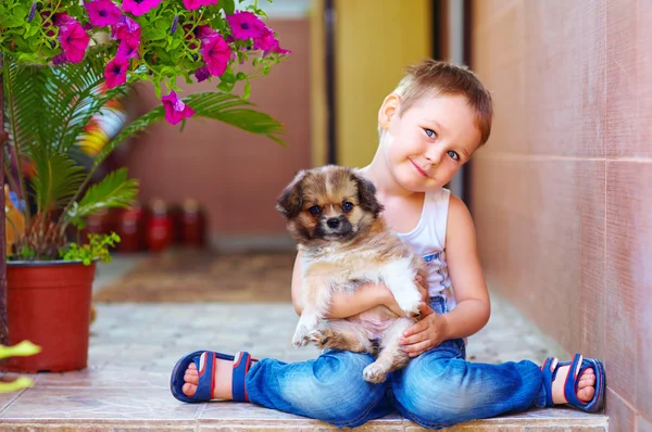 Joven chico abrazando poco cachorro — Foto de Stock