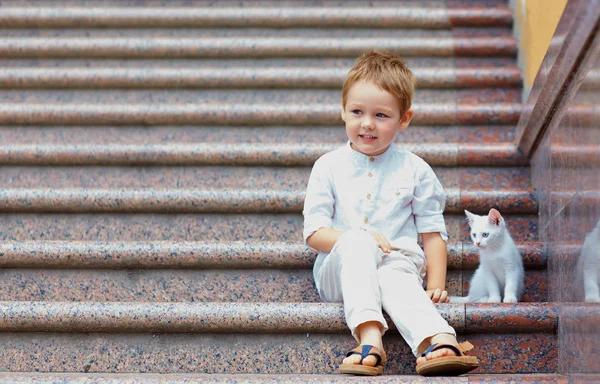 Lindo niño y pequeño gatito sentado en las escaleras — Foto de Stock