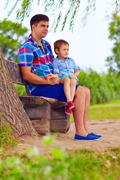 Père et fils assis sur le banc sous un saule — Photo