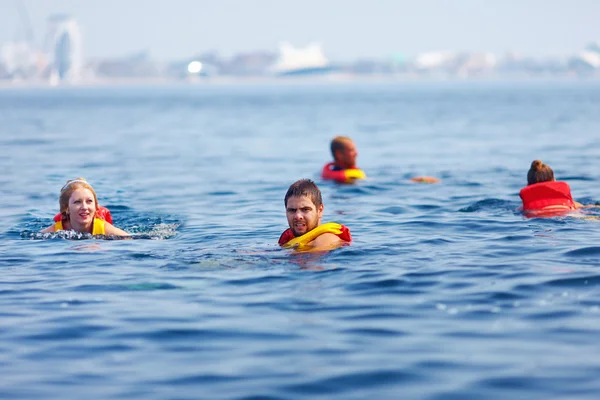 Люди в рятувальних жилах, які плавають у відкритому морі — стокове фото