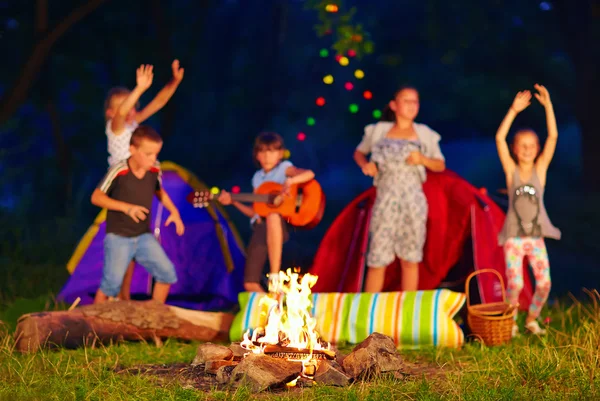 Les enfants s'amusent autour du feu de camp. focus sur le feu — Photo