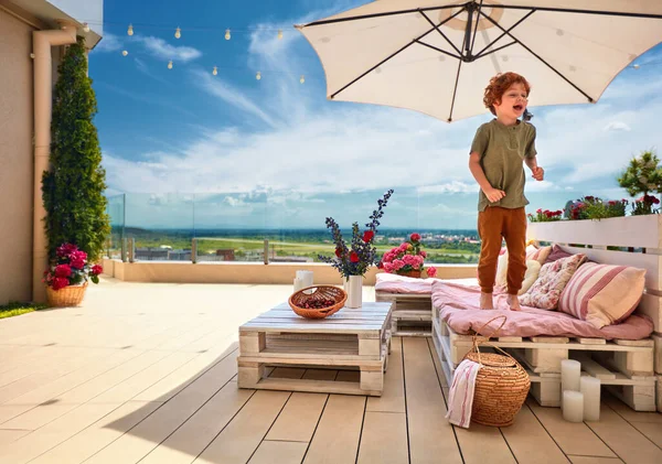 Smiling Kid Having Fun Jumping Lounge Area Made Wooden Pallets — Stock Photo, Image