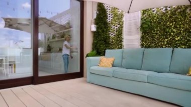 Genç çocuk sürgülü kapıyı açar, çatı katındaki terasa gider.