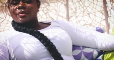 Göz kamaştırıcı genç kadın güneşli bir günde sallanan sandalyede dinleniyor