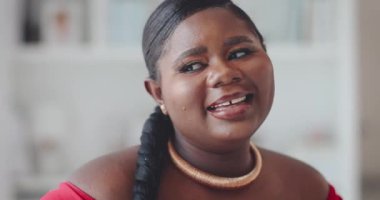 Evde poz veren gülümseyen genç kadının portresi.