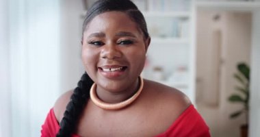 Evde gülümseyen genç bir kadının portresi.