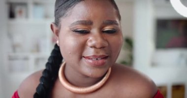 Kameraya poz vermiş, gülümseyen genç bir kadının portresi.