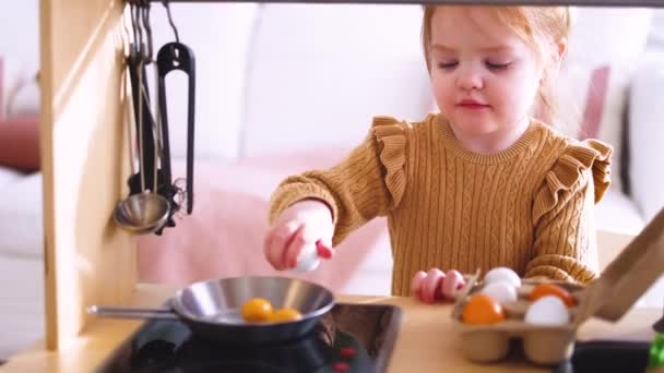 귀여운 장난감 주방에서 아침에 계란을 튀기는 척하고 — 비디오
