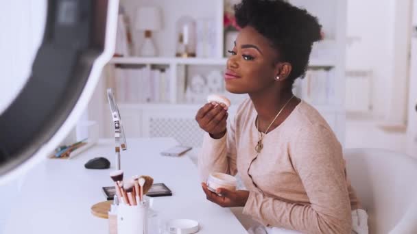幸せな若いアフリカ系アメリカ人女性が自宅から美容ブログをストリーミング オンラインコンテンツ作成者は 上のメイクを適用します — ストック動画