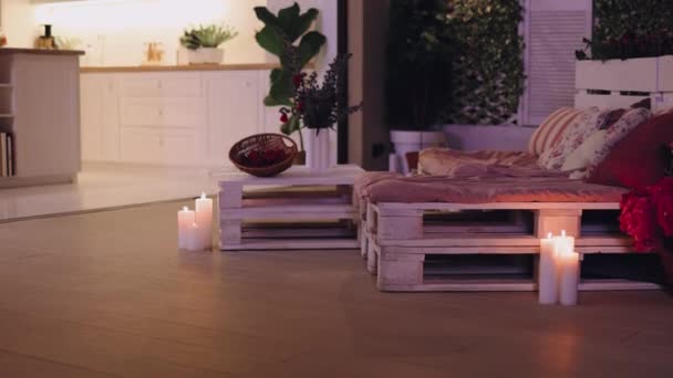 パレット家具とオープンスペースキッチン付きの居心地の良いパティオで夏の夜 — ストック動画