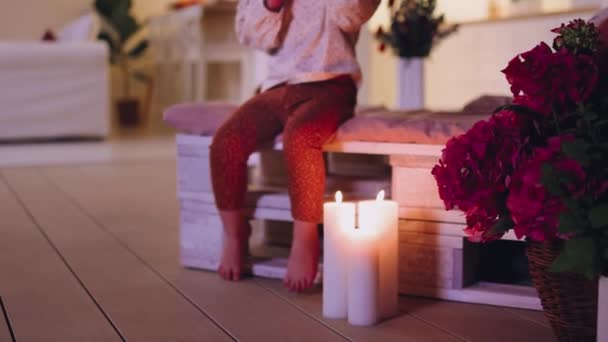幼児の赤ん坊の女の子の小さな足夏のパティオの木製のパレットソファに座って暖かい夜 — ストック動画