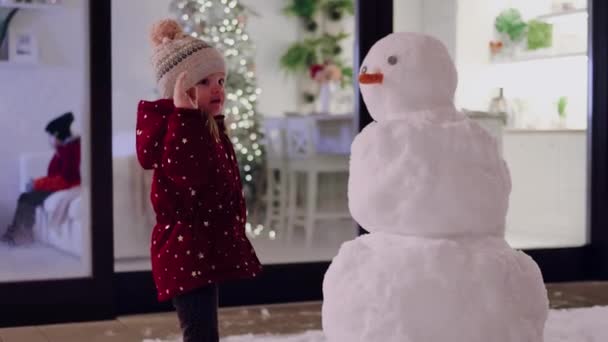 Baby Mädchen Hat Spaß Spielt Mit Schneemann Auf Der Terrasse — Stockvideo