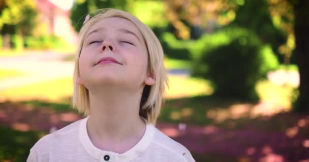 Anak Laki Laki Pirang Bahagia Bawah Hujan Bunga Taman Musim — Stok Video