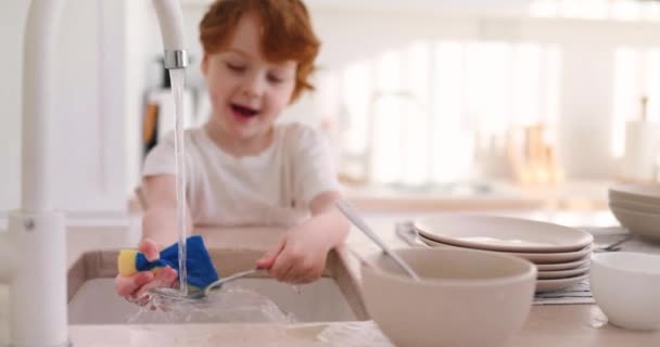 陽気な子供は水道水の下でフォークや皿を洗い — ストック動画