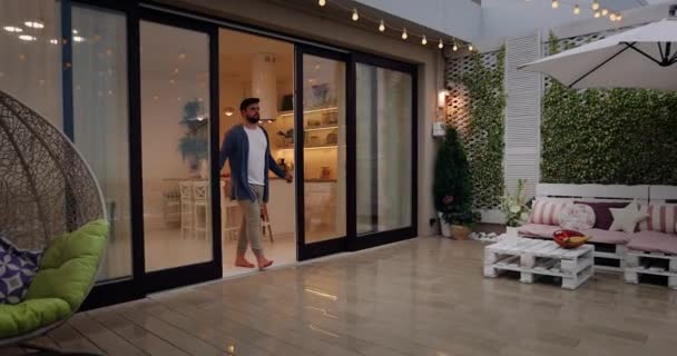 Mann Öffnet Schiebetüren Und Geht Auf Dachterrasse Mit Gemütlicher Lounge — Stockvideo