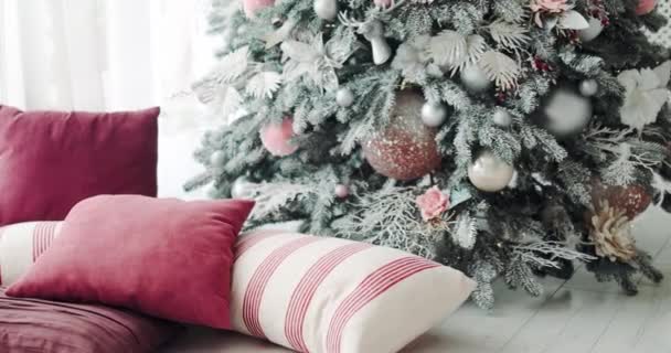 きらびやかな玉と花で飾られた雪のクリスマスツリーの閉鎖床に居心地の良い枕で — ストック動画
