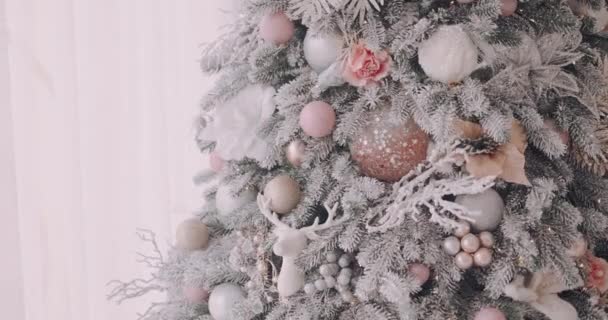 Close Van Besneeuwde Kerstboom Versierd Met Glinsterende Ballen Bloemen Rendieren — Stockvideo