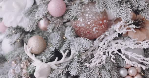 Närbild Snöig Julgran Dekorerad Med Glittrande Bollar Blommor Och Renar — Stockvideo