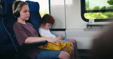 Banliyö treninde oturan çocuklar. toplu taşıma ile seyahat