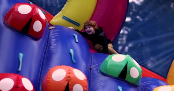 Enfant Souriant Amusant Sur Aire Jeux Gonflable Escalade Mur Coloré — Video