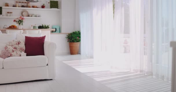 キッチンエリアとパティオゾーン 居心地の良いアパートのオープンスペースのリビングルームで夏の風に揺れるカーテン — ストック動画