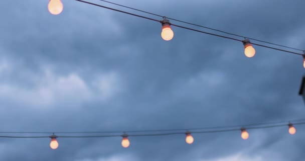 Die Reihen Von Glühbirnenschnüren Über Dem Wolkenverhangenen Himmel — Stockvideo