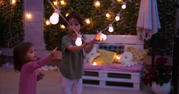 Niños Divierten Patio Azotea Noche Verano Jugando Con Luces Cadena — Vídeo de stock