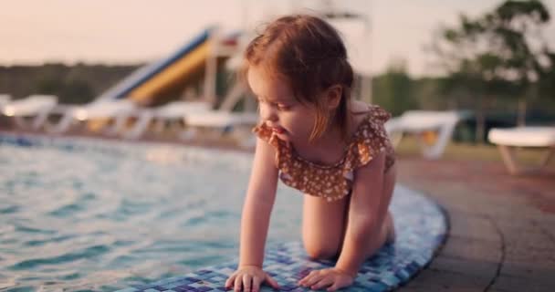 可爱的蹒跚学步的小女孩在游乐园的游泳池边玩乐 — 图库视频影像